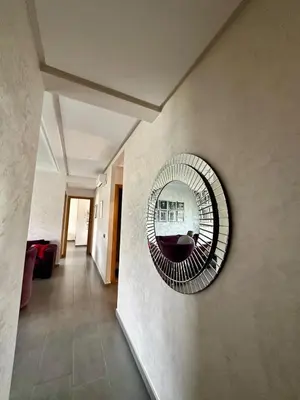 a mirror hanging on a wall in a hallway at Appartement Blanca Beach in Sidi Rahal
