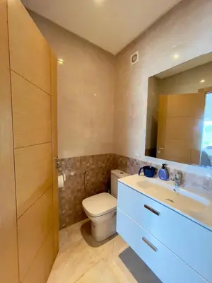 a bathroom with a toilet and a sink and a mirror at Appartement Pied dans l'eau avec terrasse-Casa bay in Sidi Rahal