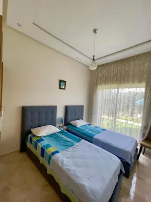two beds sitting next to each other in a bedroom at Appartement Pied dans l'eau avec terrasse-Casa bay in Sidi Rahal