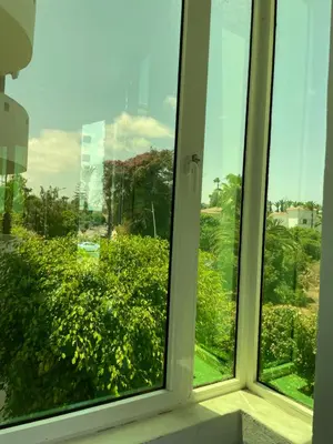 a window with a view of a green bush at Beach palace 1 between sea pool and city center in Mohammedia