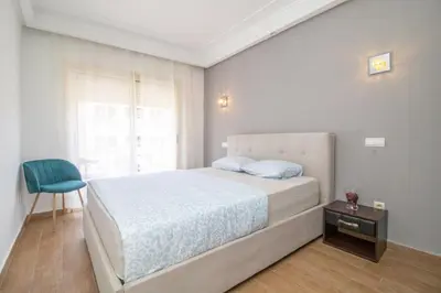 a bedroom with a bed and a blue chair at Anfa Dream in Casablanca