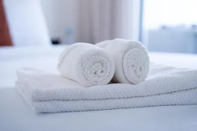 a stack of white towels on a bathroom counter at Appartement avec Piscine dans Résidence Privée in Dar Bouazza