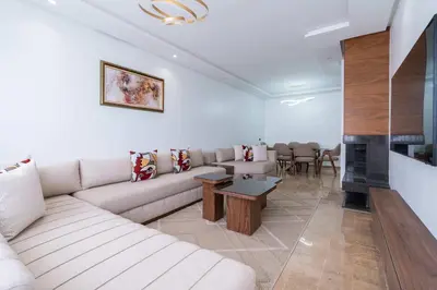 a living room with a couch and a fireplace at Appartement avec Piscine dans Résidence Privée in Dar Bouazza