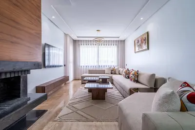 a living room with a couch and a fireplace at Appartement avec Piscine dans Résidence Privée in Dar Bouazza