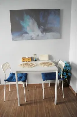 a white table with two chairs and a painting on the wall at Luxe Bleu Studio Rabat in Rabat
