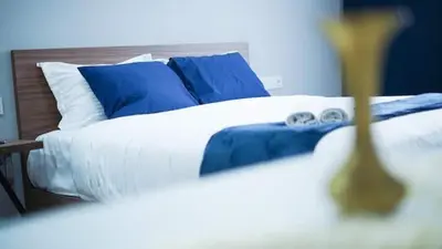 a bed with blue and white sheets and blue pillows at Luxe Bleu Studio Rabat in Rabat
