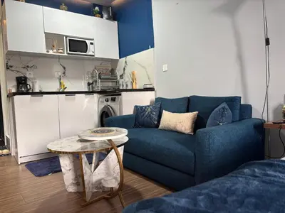 a living room with a blue couch and a table at Luxe Bleu Studio Rabat in Rabat
