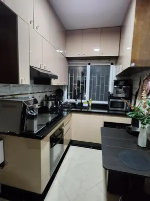 a kitchen with white cabinets and black appliances at Chambre pour une femme ou pour un couple dans un Appartement de luxe bien situé et bien équipé in Rabat