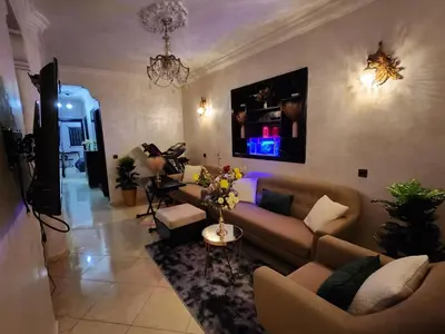 a living room with a couch and a table at Chambre pour une femme ou pour un couple dans un Appartement de luxe bien situé et bien équipé in Rabat