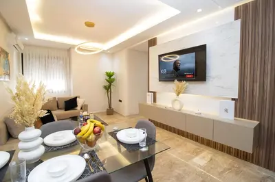 a living room with a table and a television on a wall at Magnífico apartamento in Casablanca