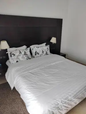 a large white bed with pillows on top of it at Appartement meublé in Temara