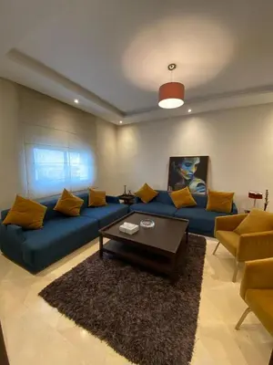 a living room with a blue couch and a coffee table at Appartement meublé in Temara