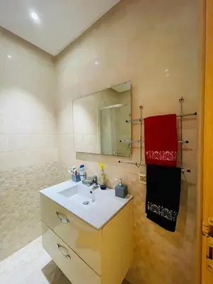 a bathroom with a sink and a mirror at Bel appartement vue piscine in Bouznika