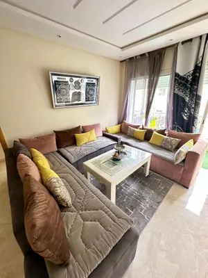 a living room with a couch and a table at Bel appartement vue piscine in Bouznika