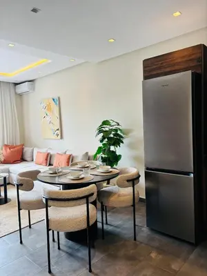 a kitchen and living room with a table and a refrigerator at Bright & Cozy Apt with City View in Casablanca
