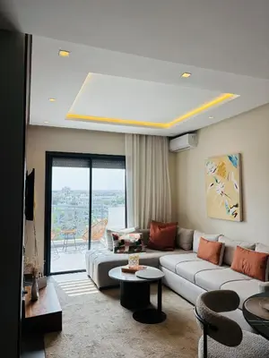 a living room with a couch and a table at Bright & Cozy Apt with City View in Casablanca