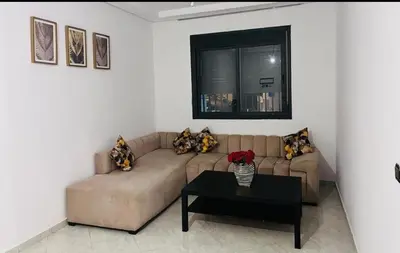 a living room with a couch and a table at A coté hôpital M6,Proche d'Aéroport et la gare bouskoura in Bouskoura