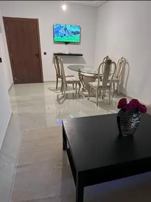 a living room with a table and chairs and a television at A coté hôpital M6,Proche d'Aéroport et la gare bouskoura in Bouskoura