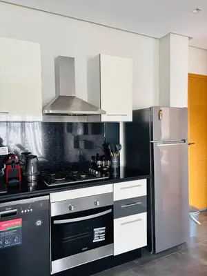a kitchen with a stove and a refrigerator at Charming Apartment With City View in Casablanca