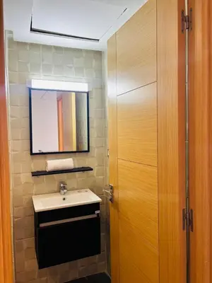 a bathroom with a sink and a mirror at Charming Apartment With City View in Casablanca