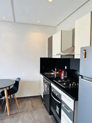 a kitchen with a black counter and a table at Charming Apartment With City View in Casablanca