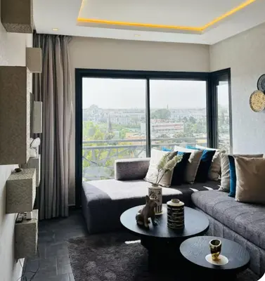 a living room with a couch and a large window at Charming Apartment With City View in Casablanca