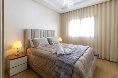 a bedroom with a large bed and a window at Cozy studio with great pool views in Aïn Harrouda