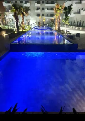 a large pool with blue lights in a building at Cozy studio with great pool views in Aïn Harrouda