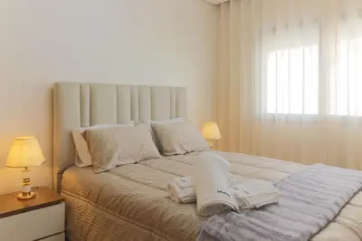a bedroom with a large bed with two books on it at Cozy studio with great pool views in Aïn Harrouda
