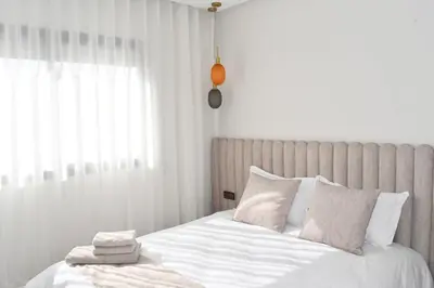 a bed with white sheets and pillows in a bedroom at Elegant Apartment with City View in Casablanca