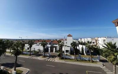 a view of a street with palm trees and buildings at Jumeirah in Sidi Rahal