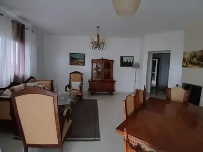 a living room with a dining room table and chairs at Appartement BAHIA BEACH piscine plage privée in Bouznika