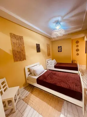 a bedroom with two beds and a chandelier at Sduisant Studio in Casablanca in Casablanca