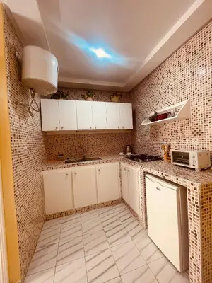 a kitchen with white cabinets and a tile wall at Sduisant Studio in Casablanca in Casablanca