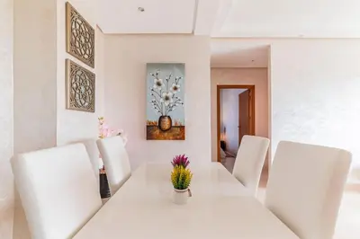 a white dining room with a white table and white chairs at L'Eden - 2 BR - Beachfront & Pool - 3 beds in Tamaris