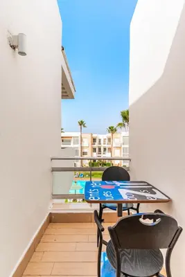 a patio with two chairs and a table on a balcony at L'Eden - 2 BR - Beachfront & Pool - 3 beds in Tamaris