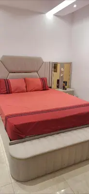 a bedroom with a large bed with red sheets at Villa au centre ville Rabat in Rabat