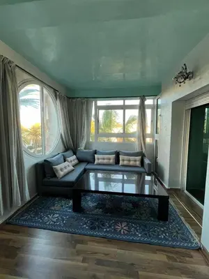 a living room with a couch and a glass table at Apartment with sea view in Mohammedia