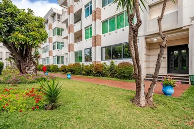 a building with trees and flowers in front of it at Apartment with sea view in Mohammedia
