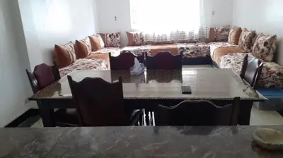 a living room with a table and a couch at Le Grand Refuge des Lilas in Casablanca