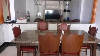 a dining room table with chairs and a television at Le Grand Refuge des Lilas in Casablanca