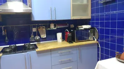 a kitchen with blue tiled walls and a counter top at Le Grand Refuge des Lilas in Casablanca