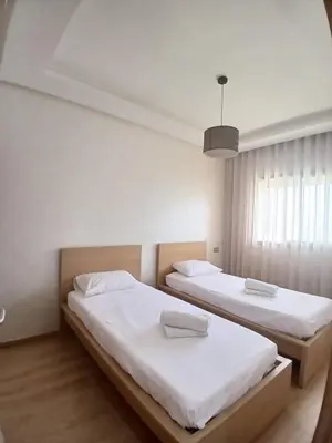 a bedroom with two beds and a window at Duplex Luxe 3 Chambres Vue Mer & Piscine à Zenata Eco City in Aïn Harrouda