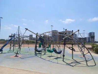 a playground with slides and swings in a park at Duplex Luxe 3 Chambres Vue Mer & Piscine à Zenata Eco City in Aïn Harrouda