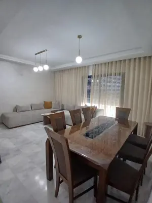 a living room with a table and a couch at Duplex Luxe 3 Chambres Vue Mer & Piscine à Zenata Eco City in Aïn Harrouda