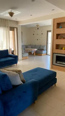 a living room with a blue couch and a fireplace at Puerto Banus Appartement A4 in Mohammedia