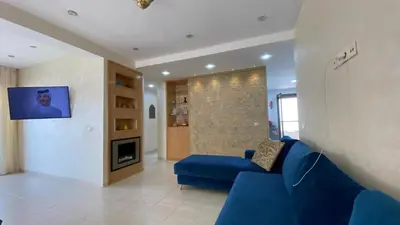 a living room with a blue couch and a tv at Puerto Banus Appartement A4 in Mohammedia