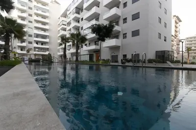a swimming pool in front of a building at Studio chic et paisible avec piscine parc et plage in Aïn Harrouda