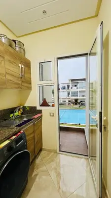 a kitchen with a sliding glass door leading to a pool at CASABAY KETTANI SIDI Rahal in Sidi Rahal