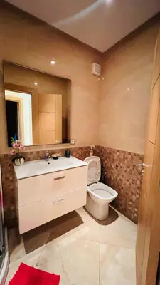 a bathroom with a toilet and a sink and a mirror at CASABAY KETTANI SIDI Rahal in Sidi Rahal